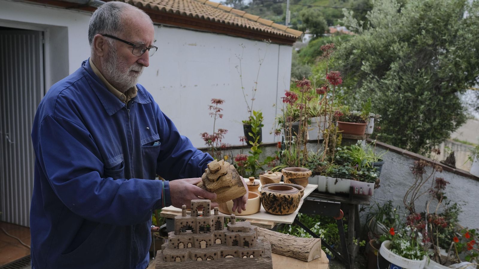 Francisco Núñez muestra uno de sus pueblos creado dentro de un tronco.