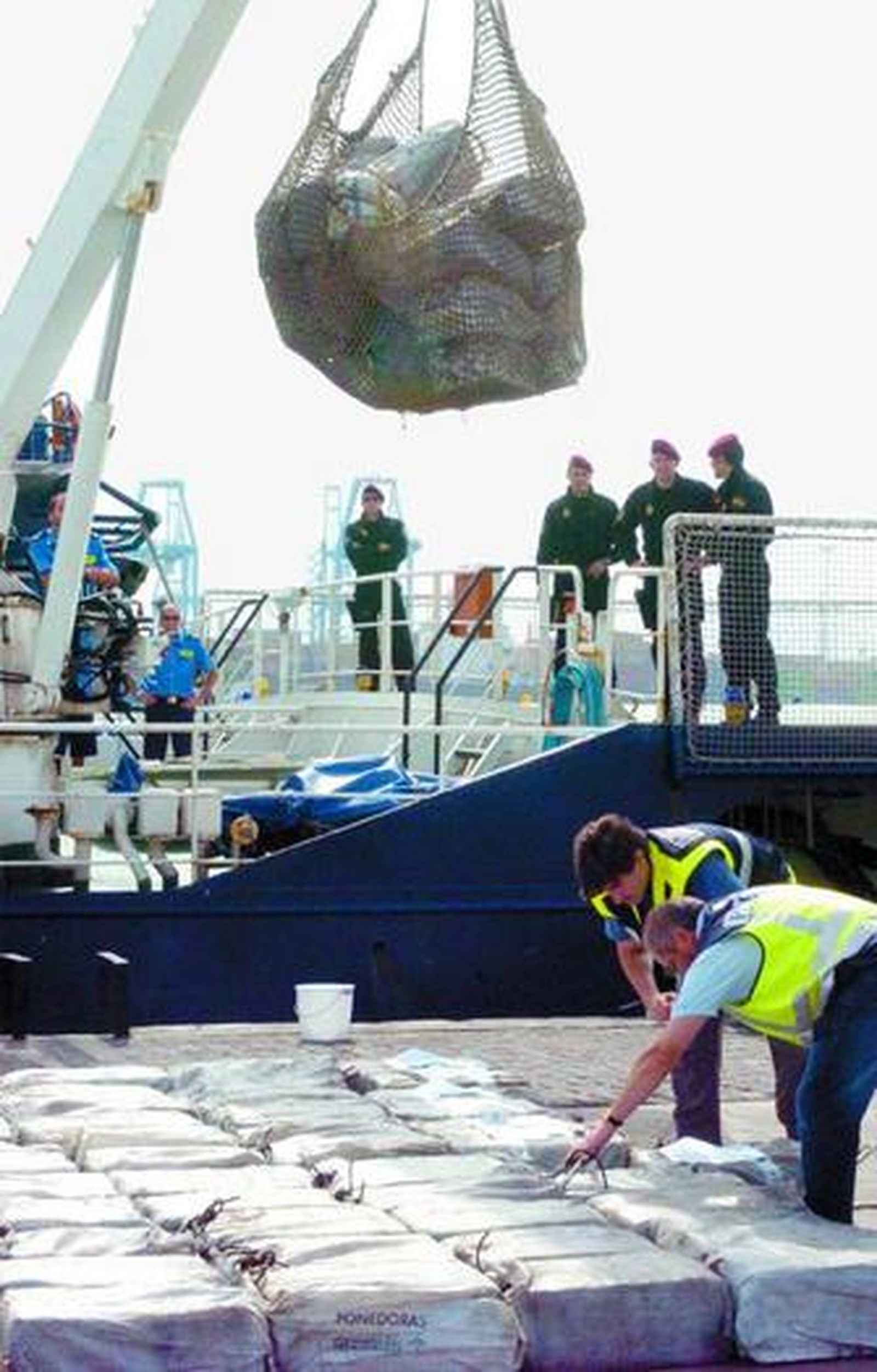 Dos operarios descargan la droga.