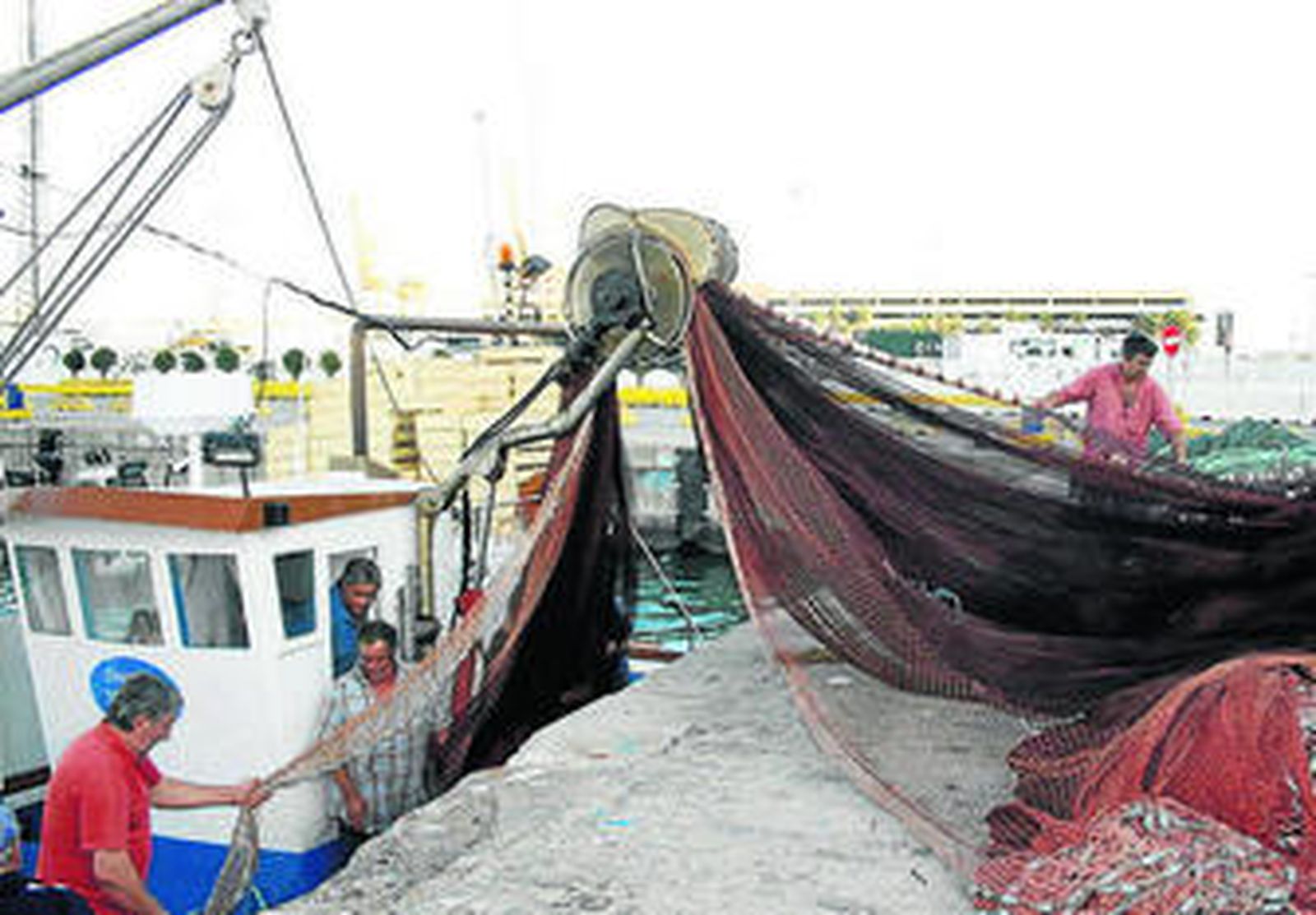 Pescadores de Algeciras descargan sus redes en el muelle.