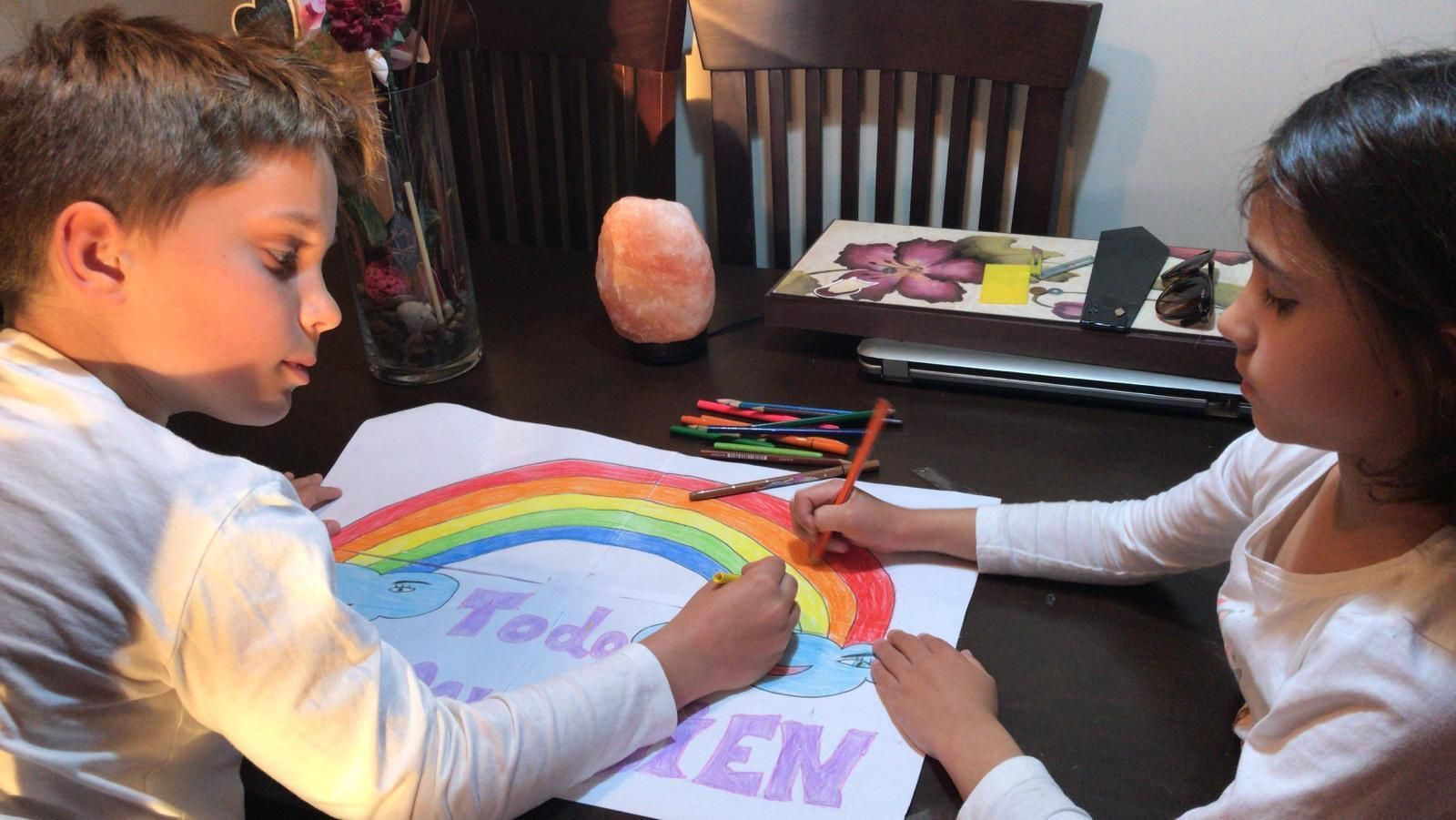 Dos pequeños realizan sus dibujos en casa