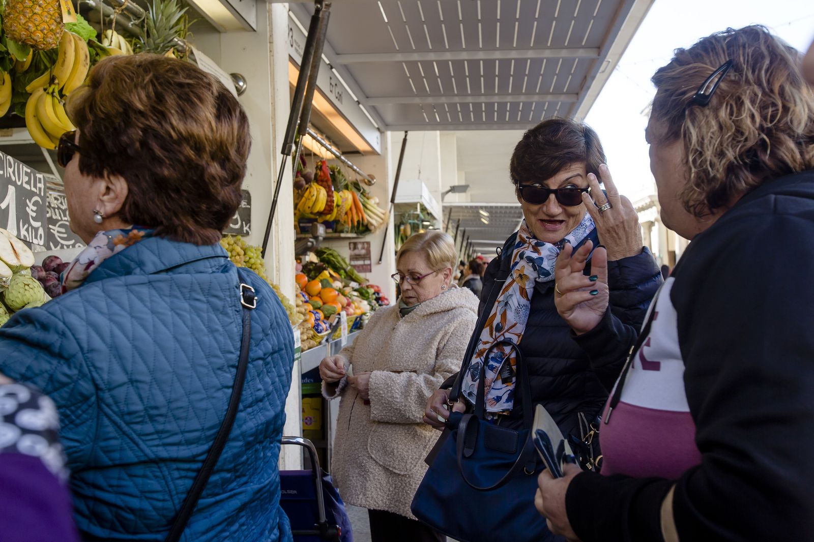 Tertulia política improvisada ante un puesto de frutas del Mercado Central.