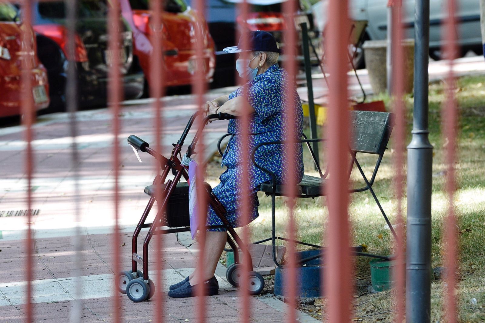 Una usuaria de una residencia de la tercera edad de Valladolid descansa en un banco.