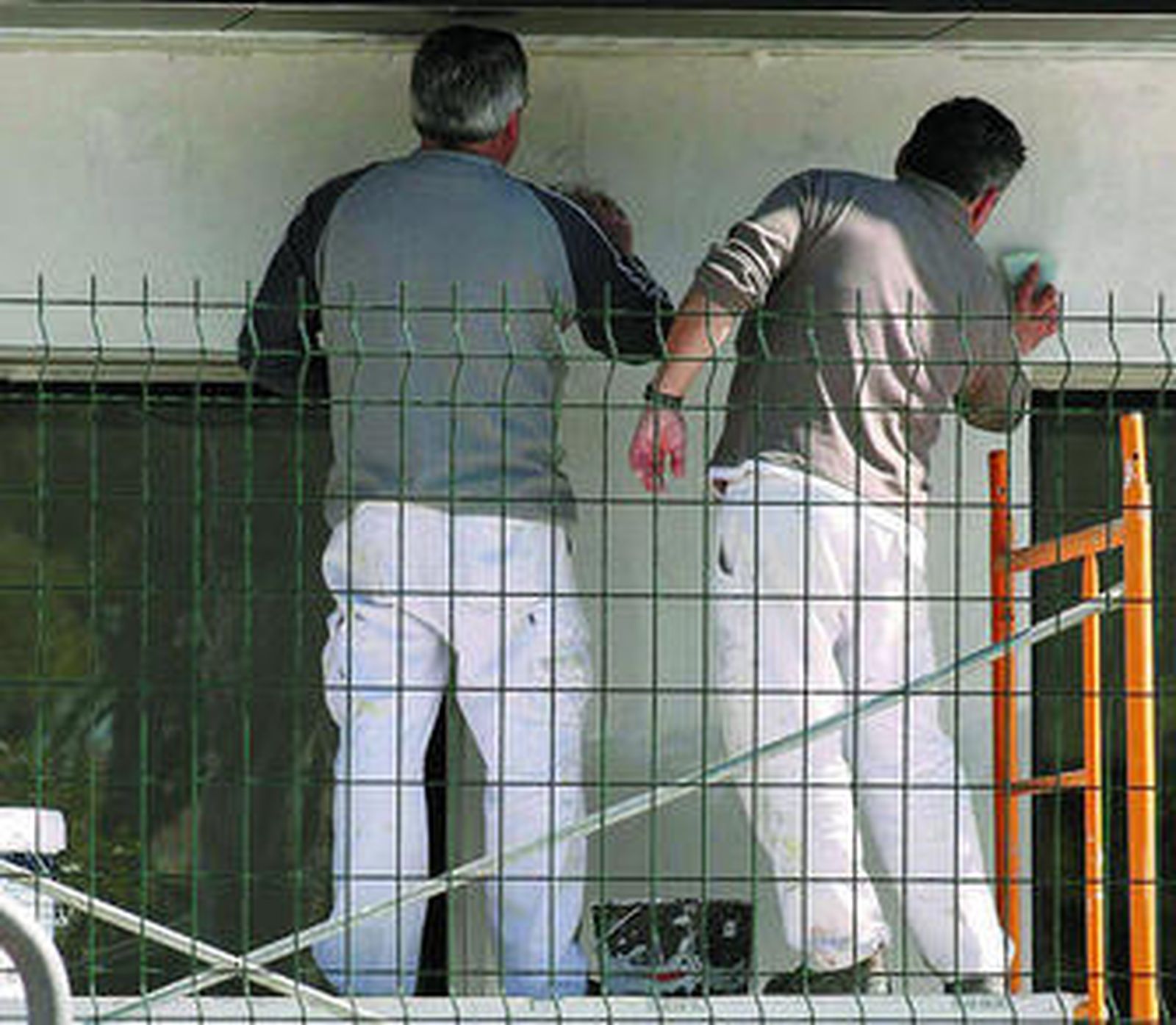 Dos obreros reformando un inmueble.