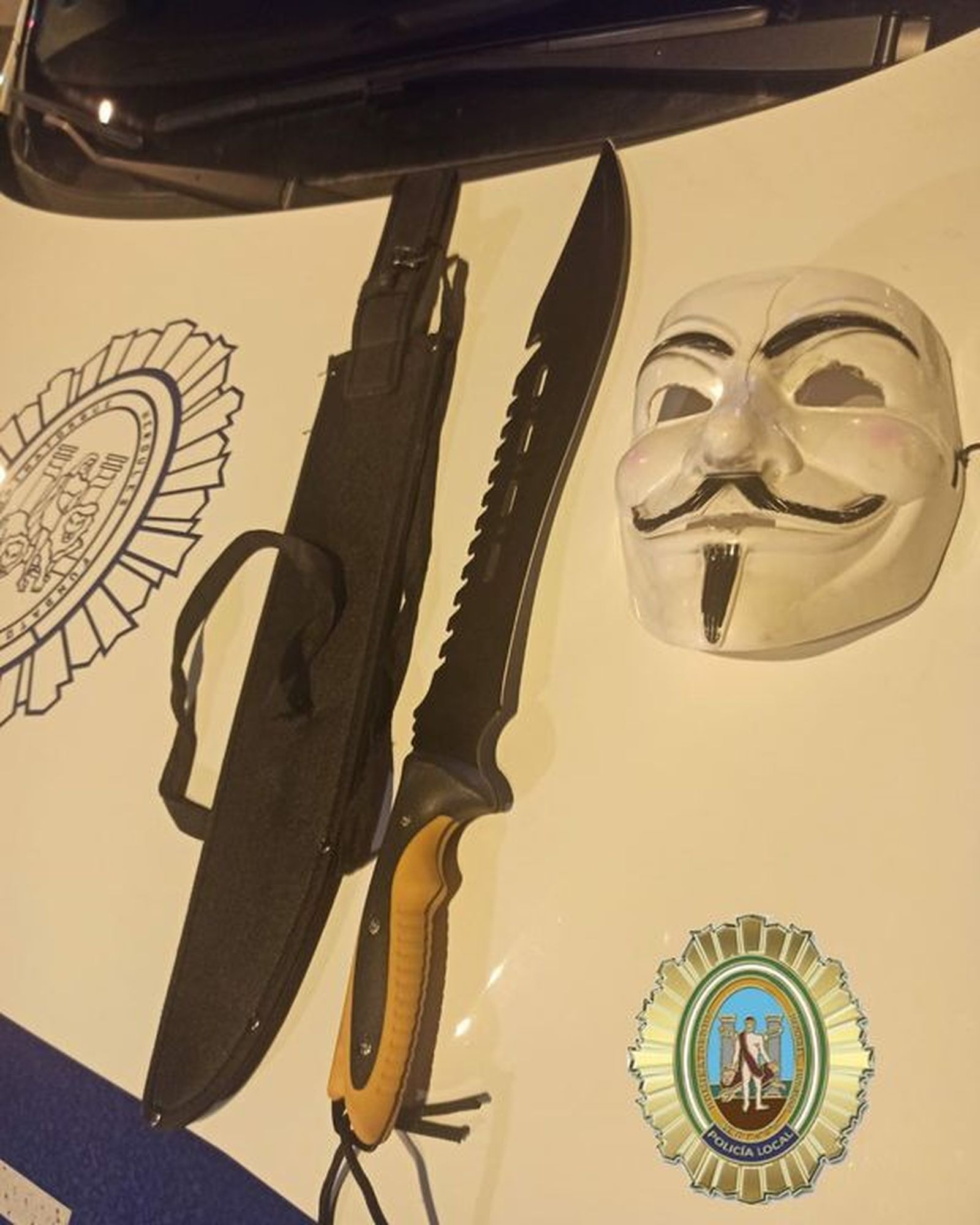 Machete de grandes dimensiones incautado, junto a una máscara