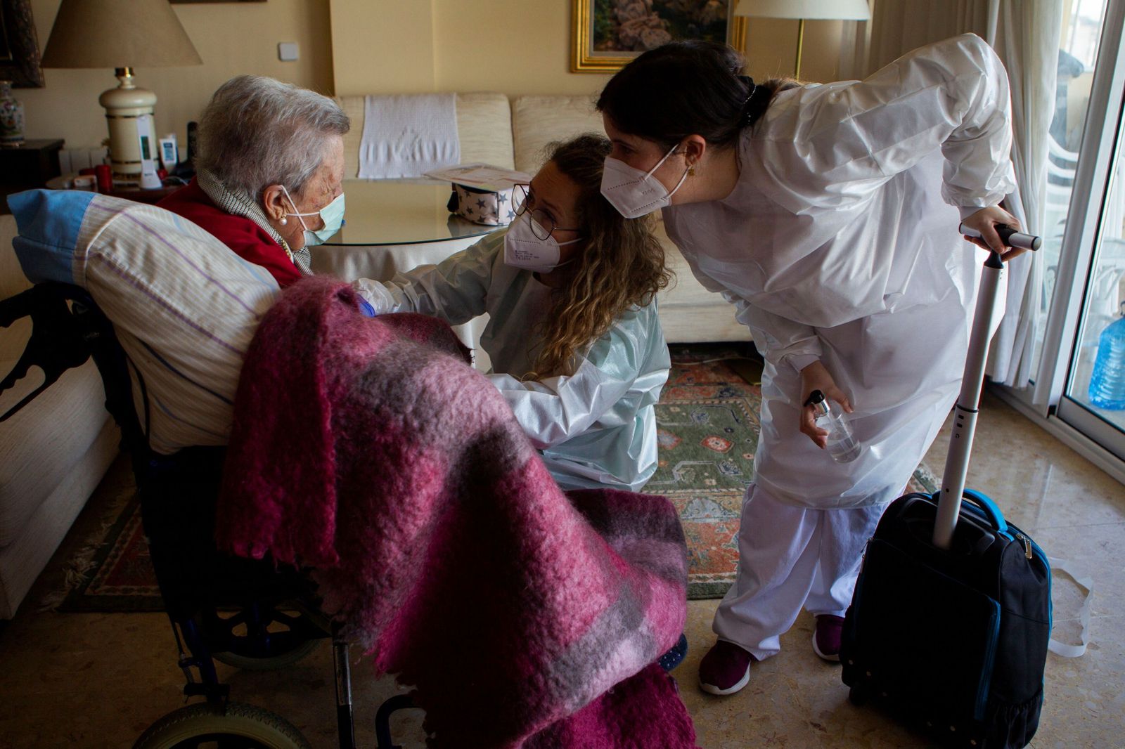 Dos enfermeras vacunando a una  anciana en su domicilio en Palma de Mallorca.