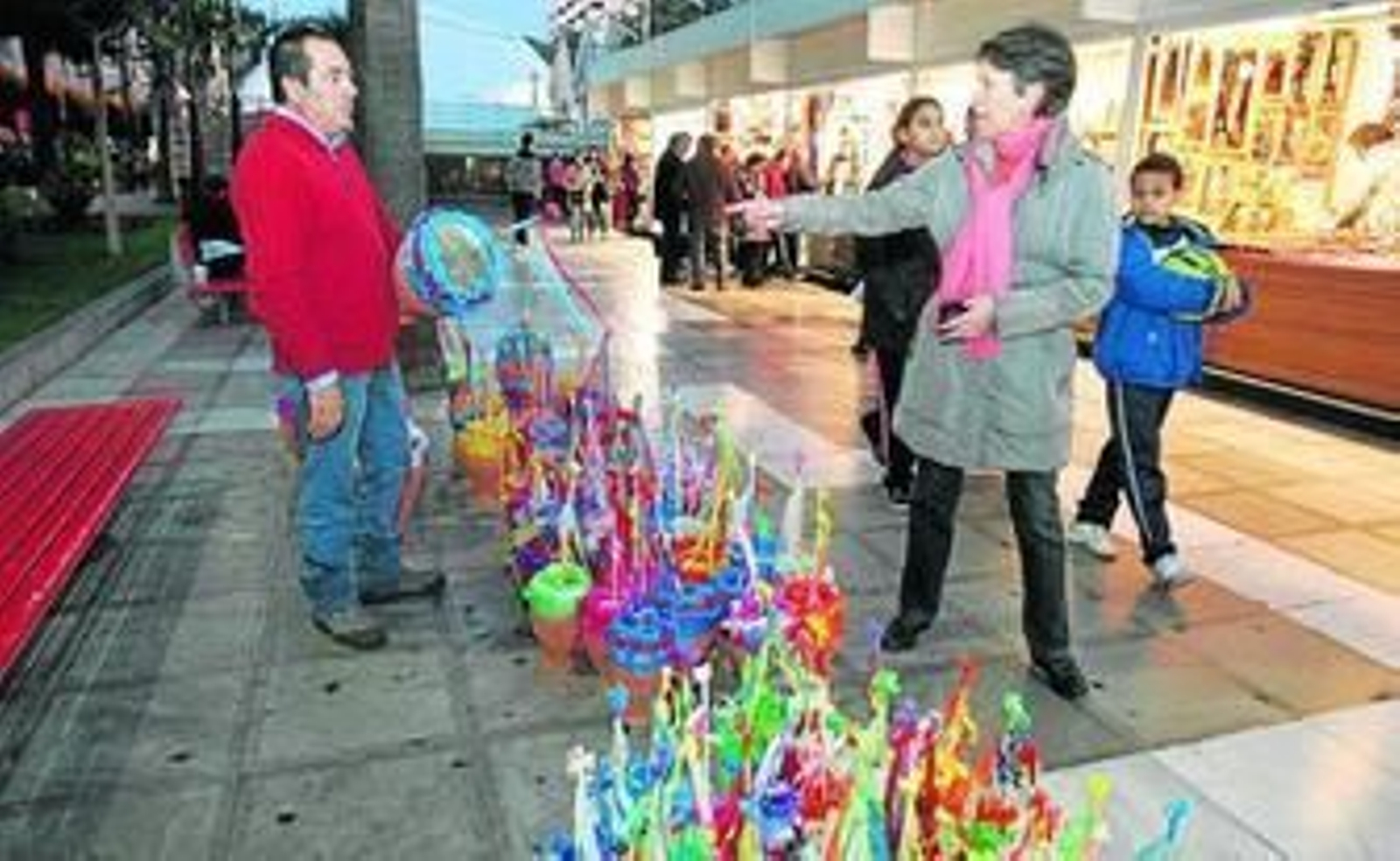 Una mujer se interesa por uno de los instrumentos que vende en la Rambla este vecino de Guadix.