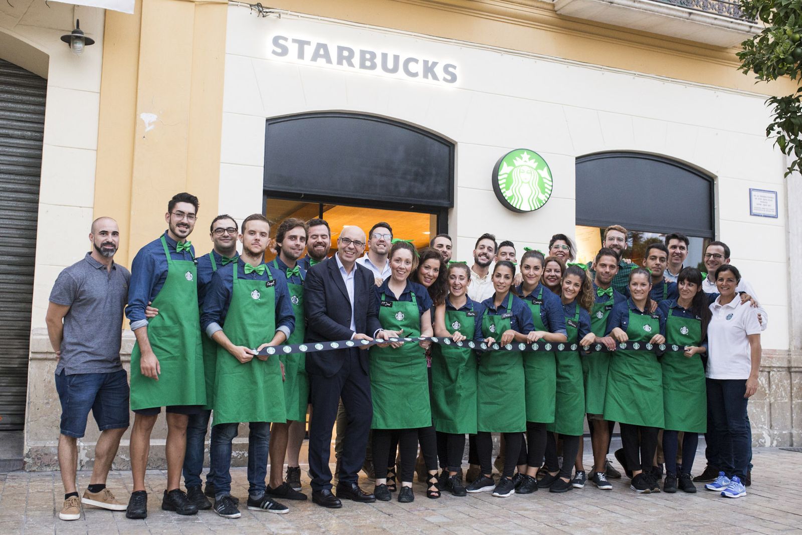 Responsables de la firma junto a la plantilla del nuevo local de la Plaza de la Merced.