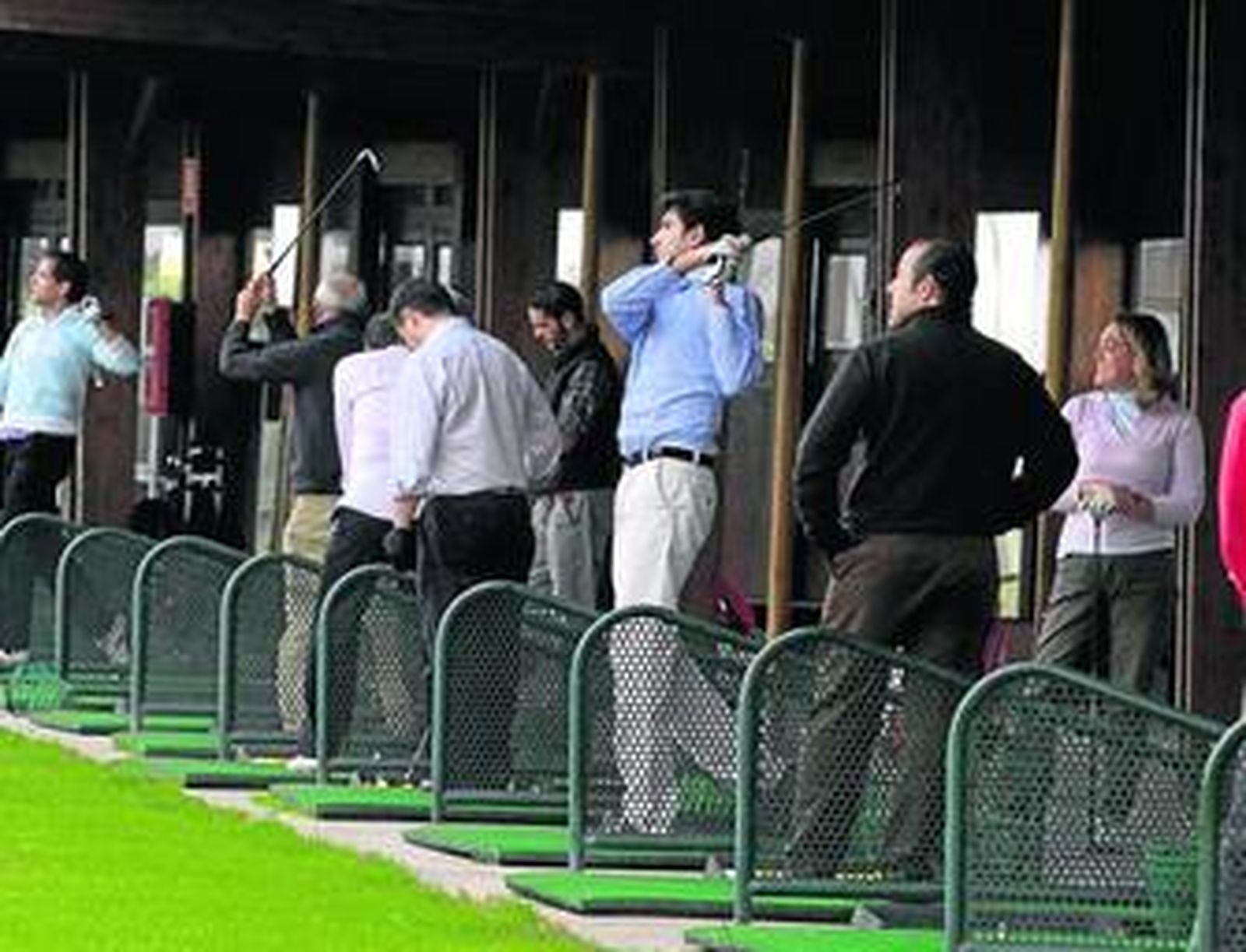 Varios usuarios de la Escuela Pública de Golf ensayan el 'swing' en la zona de 'tees'.
