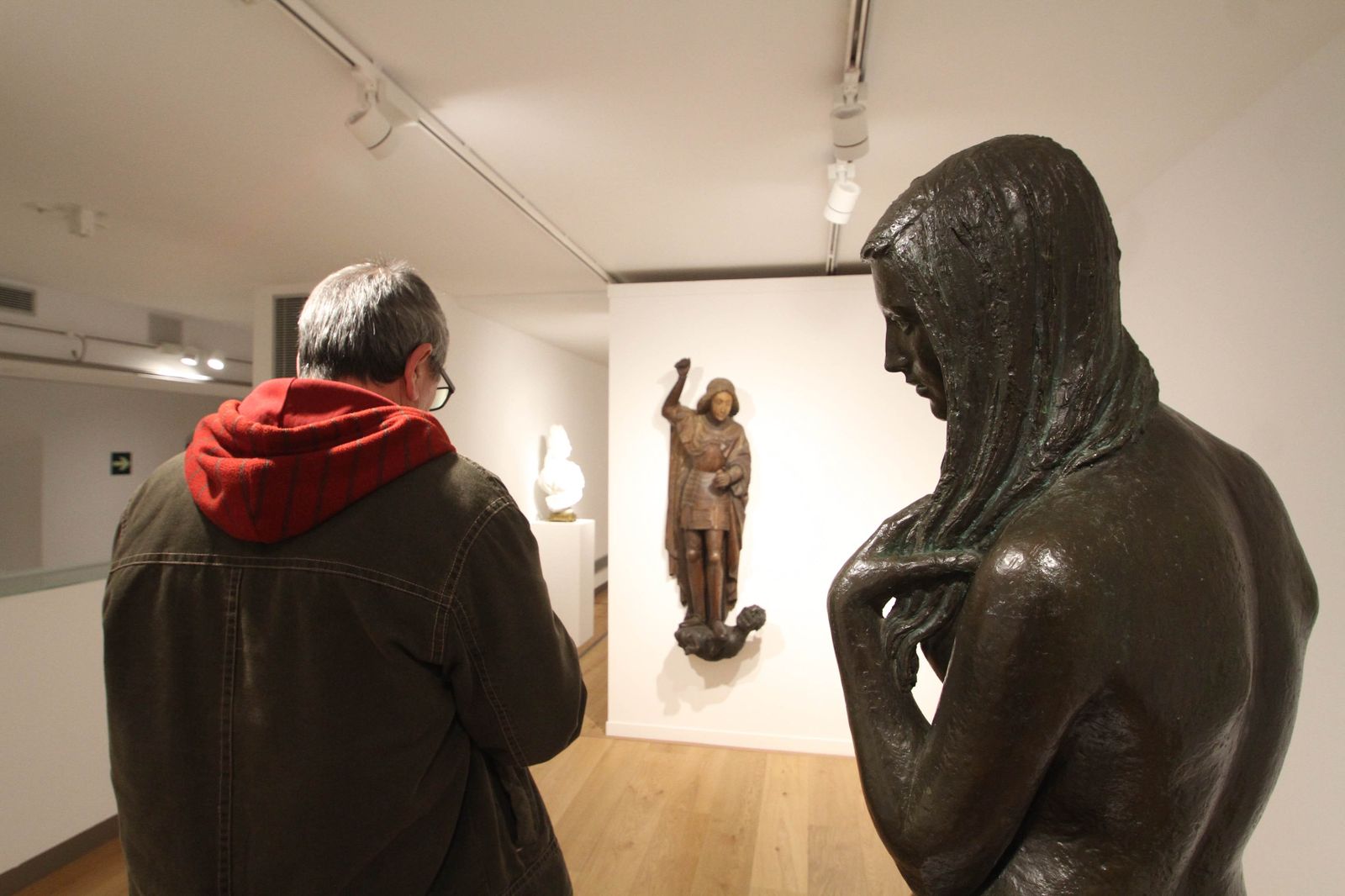 Un 'San Miguel Arcángel' que podría ser un 'San Jorge', del siglo XV frente a una escultura de Carmen Jiménez.