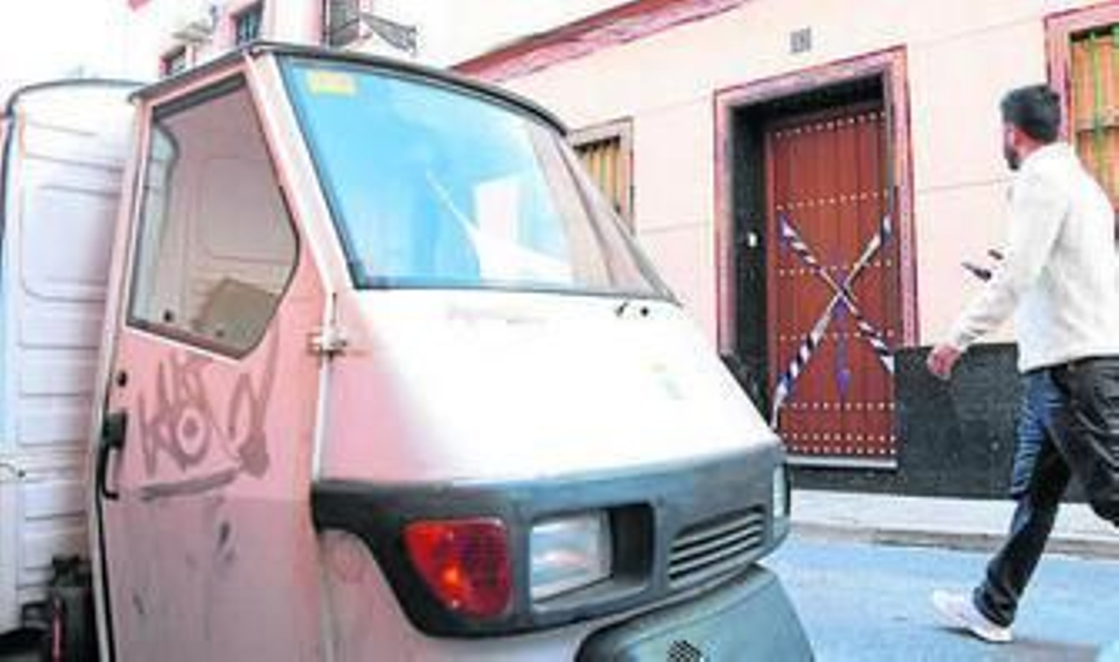El motocarro de la víctima y la puerta de la casa precintada.