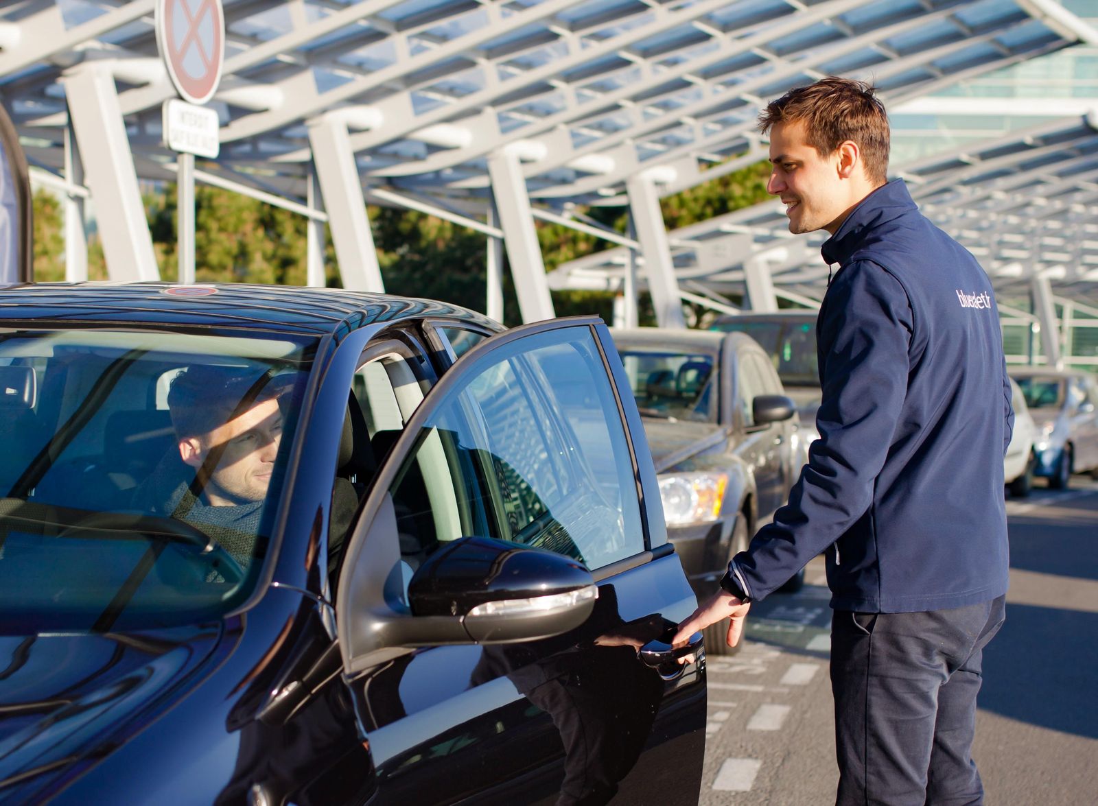 Un aparcacoches de Blue Valet recibe a un cliente en un aeropuerto.
