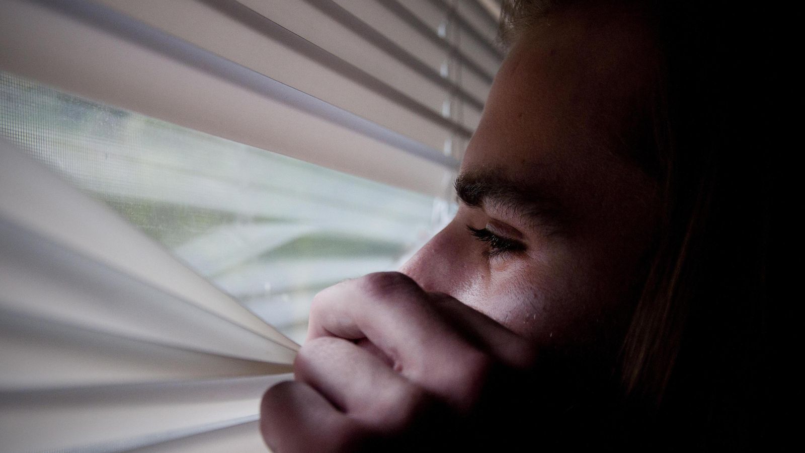 Un hombre con un cuadro depresivo mira a través de la ventana. Un hombre con un cuadro depresivo mira a través de la ventana.