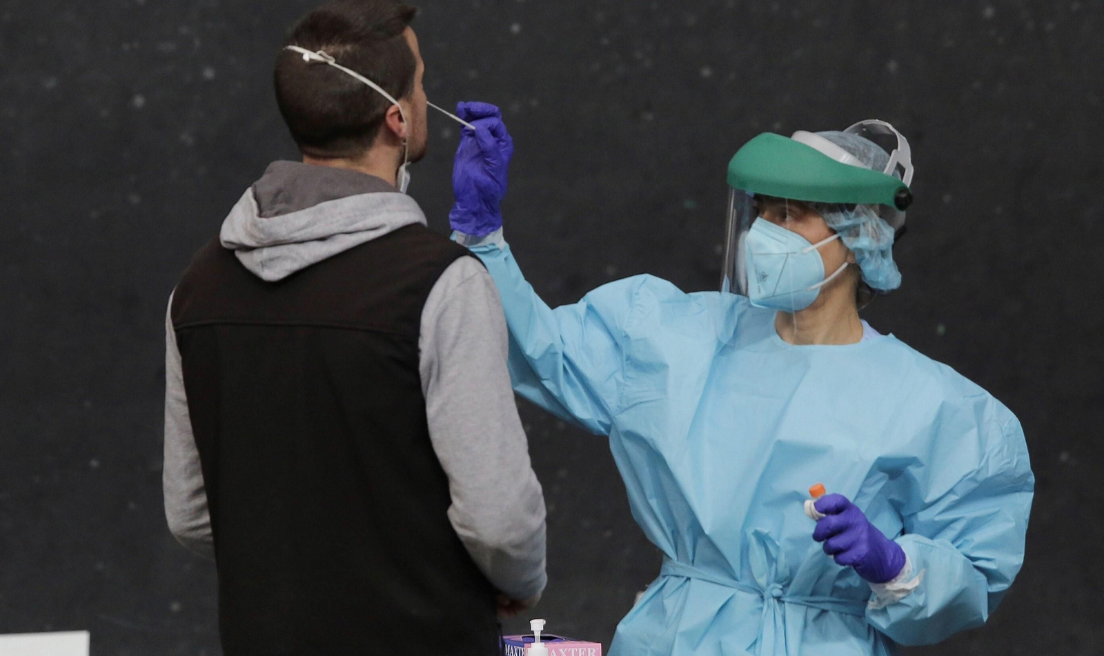 Una profesional sanitaria toma una muestra para una prueba PCR.