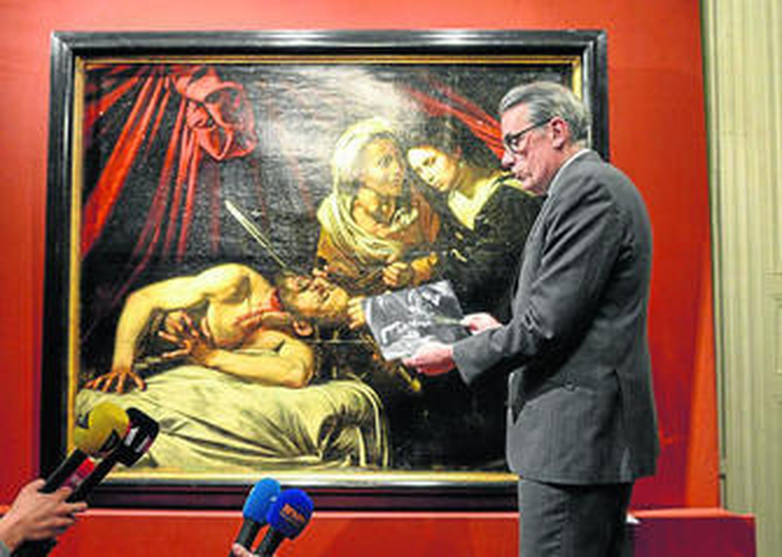 Un experto de la casa de tasación contratada por los dueños enseña el cuadro y una radiografía del mismo, ayer en París.