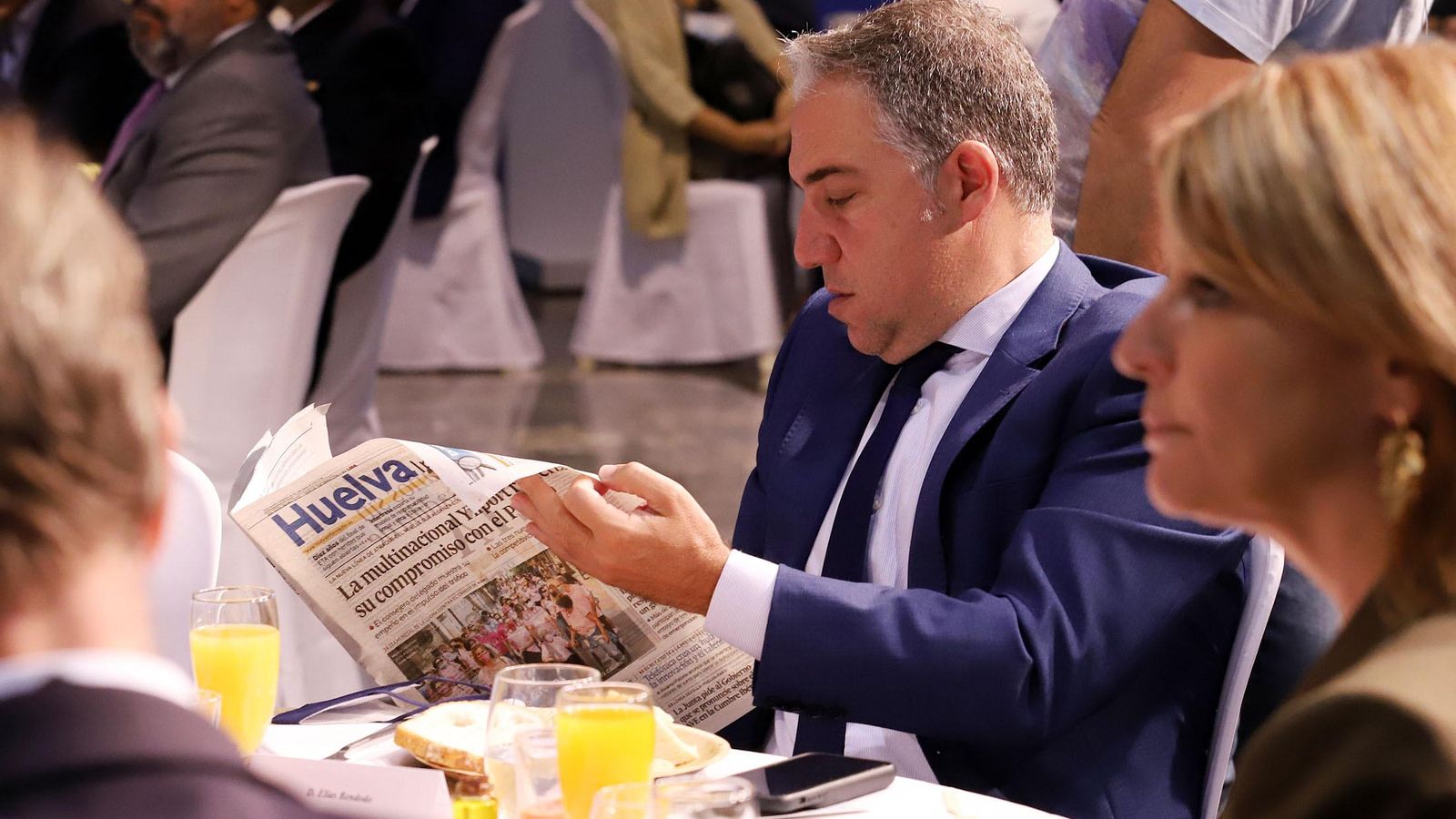 Elías Bendodo consulta un ejemplar de 'Huelva Información' en presencia de Pilar Miranda.