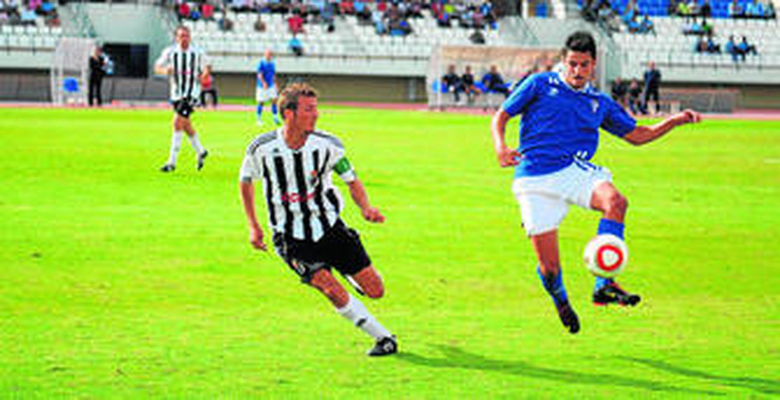 EL centrocampista del San Fernando Carlitos controla el esférico ante la presión del capitán del equipo linense, Ismael.