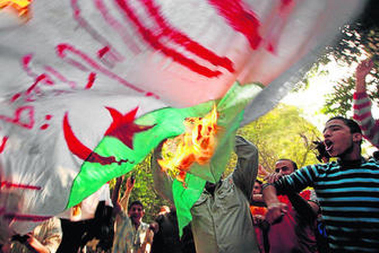 Manifestantes egipcios queman una bandera de Argelia en El Cairo.