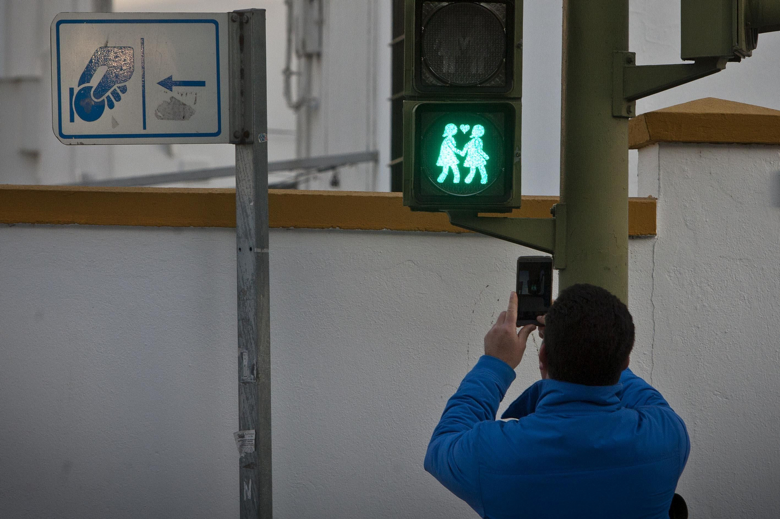Un isleño fotografía con su teléfono móvil uno de los semáforos por la diversidad, en la avenida San Juan Bosco.