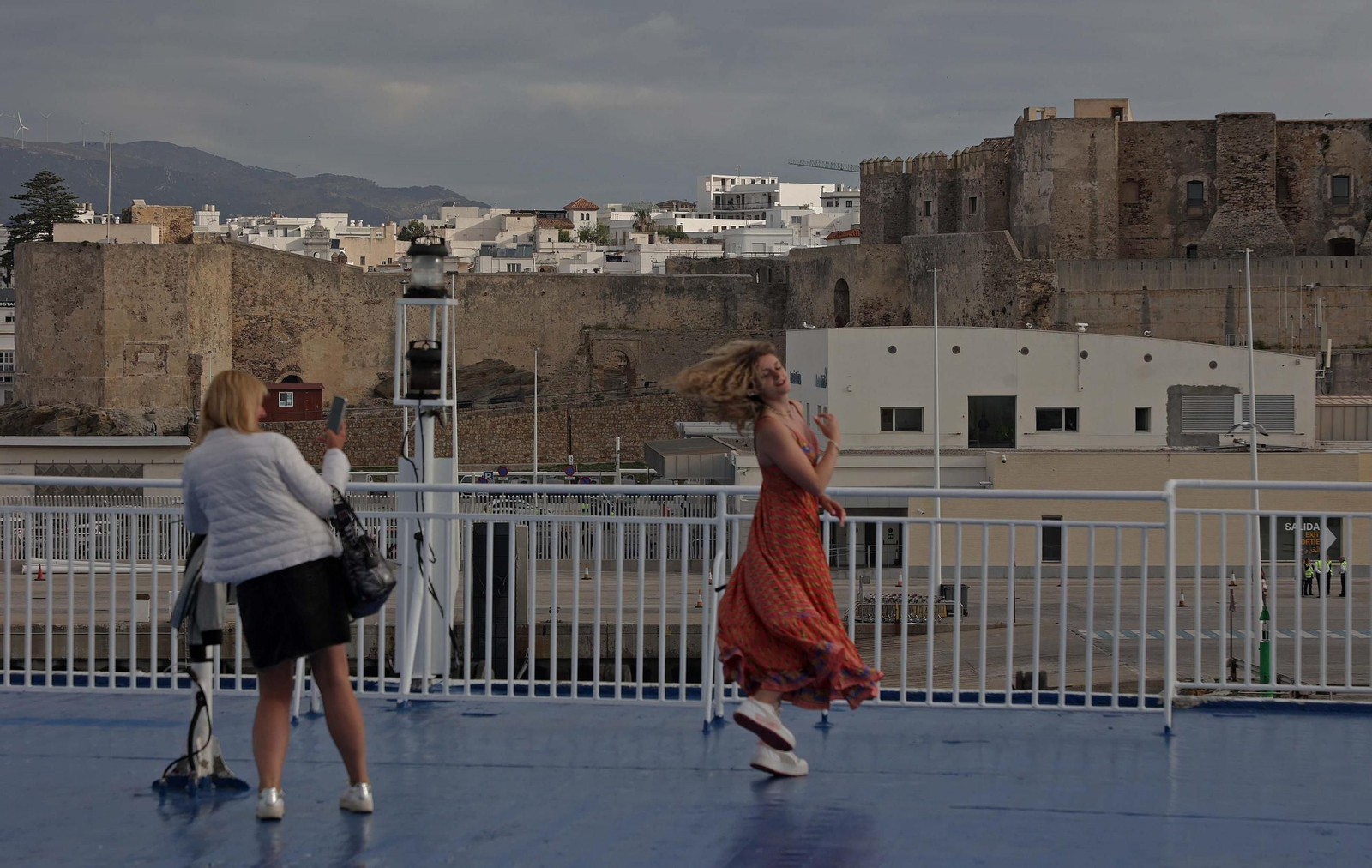 A bordo, una joven rubia vestida de naranja se graba caminando hacia la popa con esa determinación coreográfica de los 'influencers'.