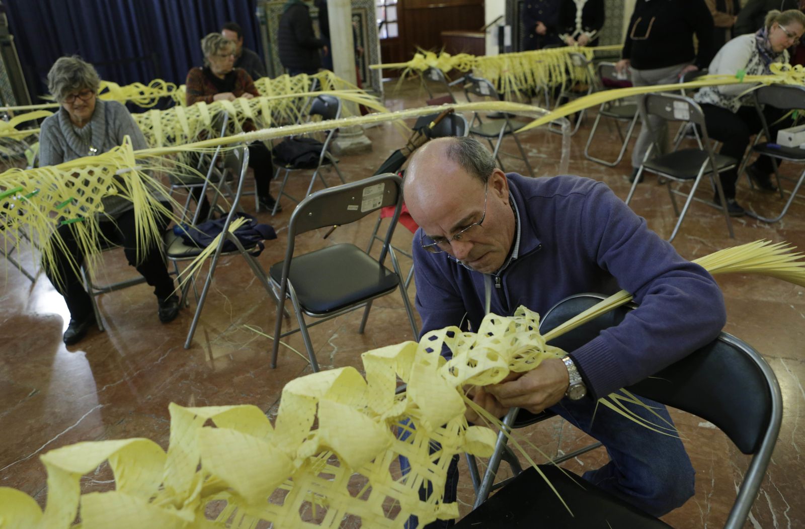 Un alumno del taller de rizado de palmas, en el patio del Círculo Mercantil de Sierpes.