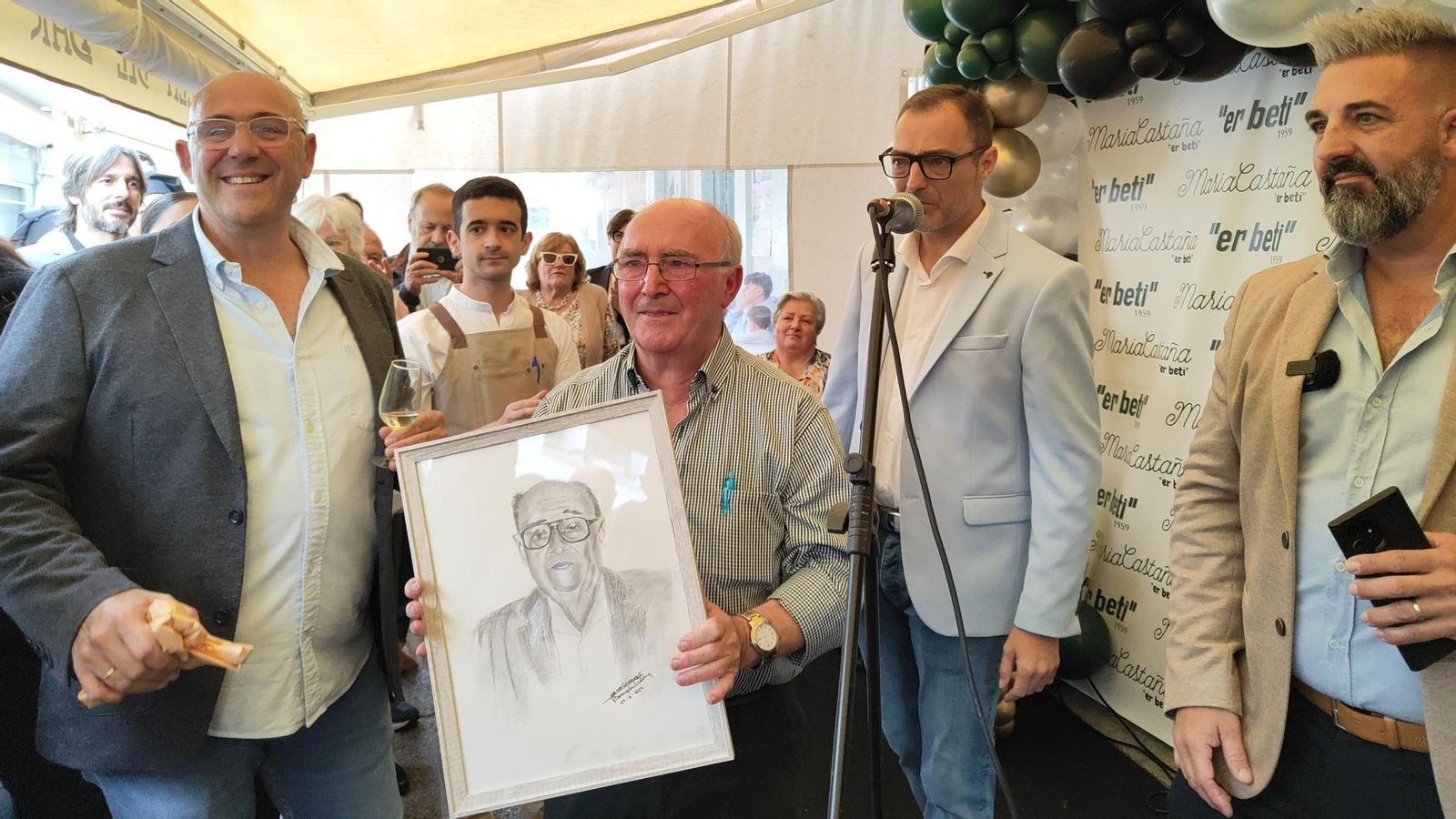 Manuel Garrido Prado recibe emocionado un retrato de su padre, Manuel Garrido Patino.