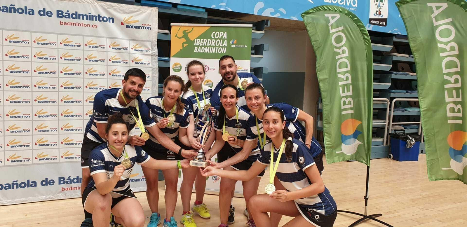 Las jugadoras y los técnicos del conjunto onubense celebran el título en el Palacio.