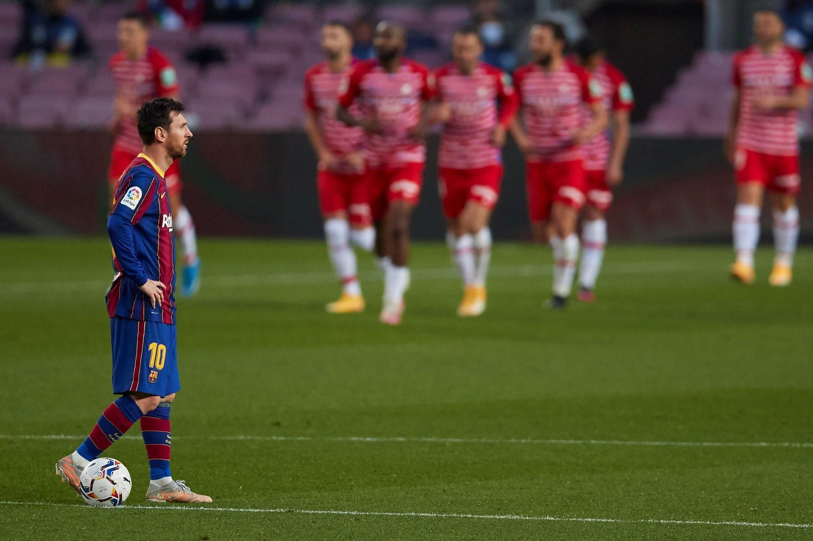 Un contrariado Lionel Messi, con el Granada celebrando uno de sus goles al fondo.