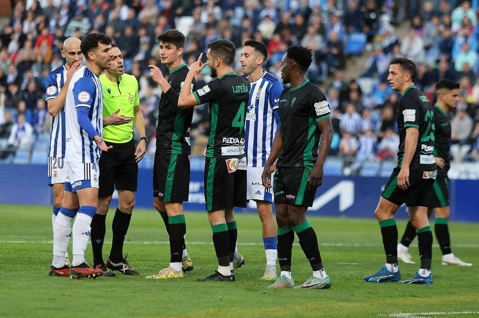 El colegiado, del Recre-Córdoba, conversa con los jugadores.
