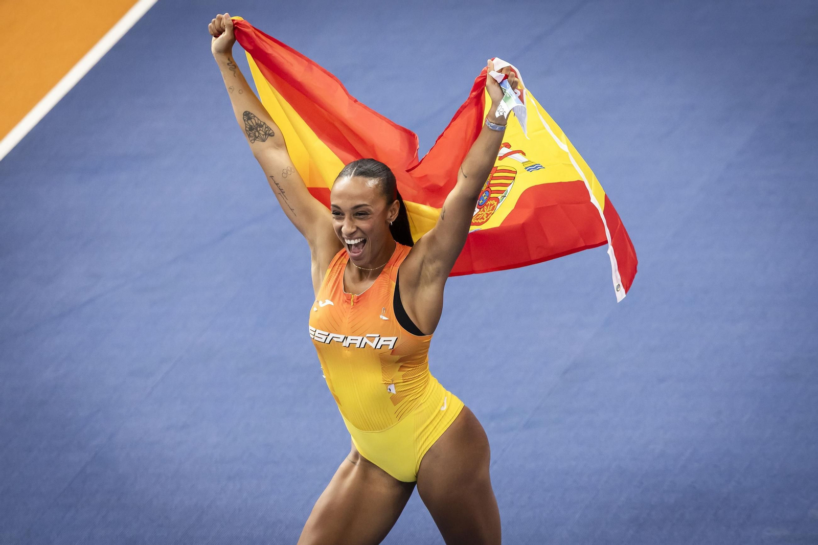 Ana Peleteiro posa con la bandera española tras ganar la final de triple salto.