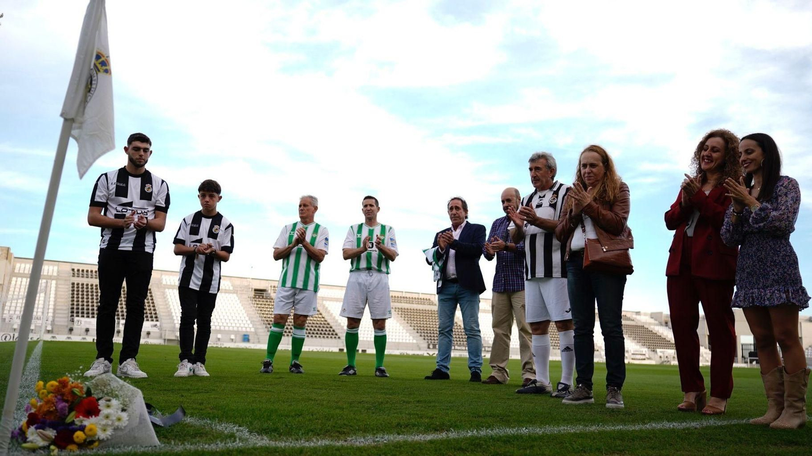 Los capitanes, Juan Merino y los familiares de Quirós, tras depositar un ramo de flores en su memoria en uno de las esquinas del terreno de juego