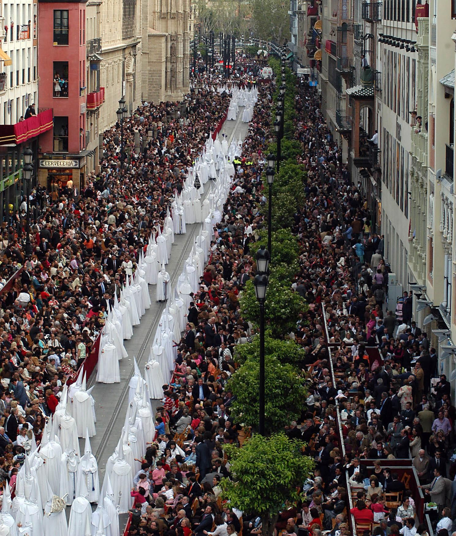 Nazarenos de la Hermandad de la Paz por la Avenida de la Constitución.