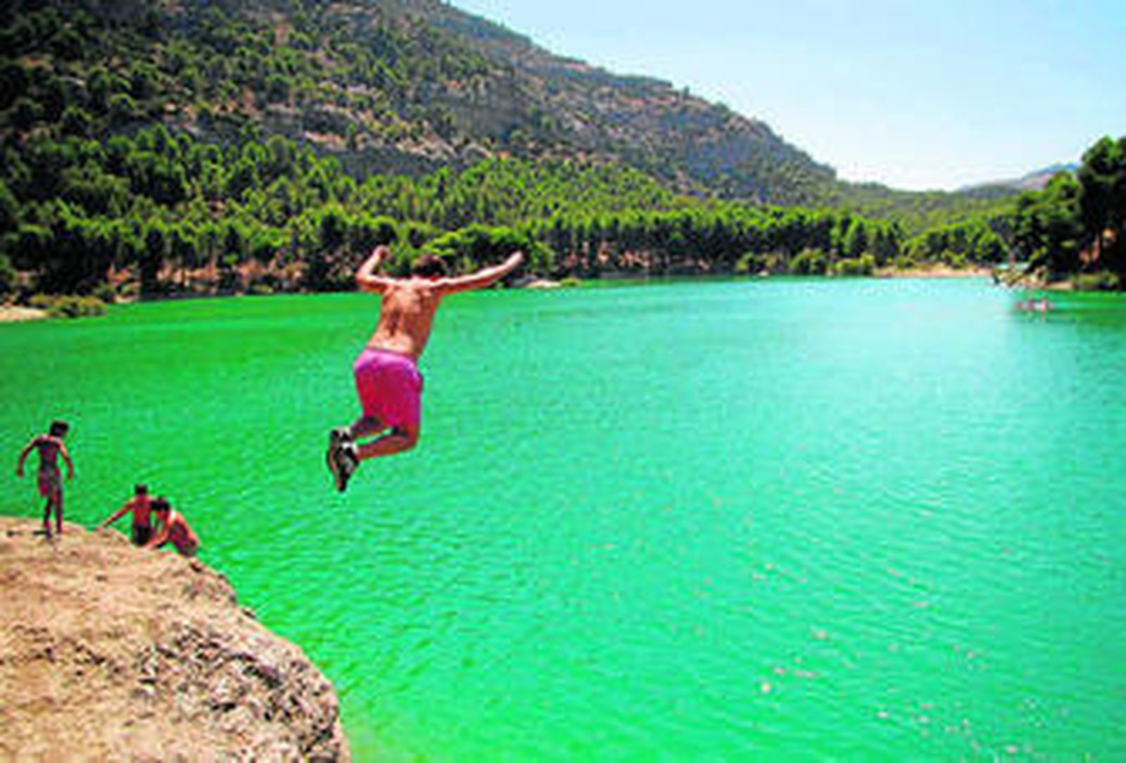 1. Un joven se zambulle en las aguas del pantano. 2. Unas niños practican con un kayak mientras dos jóvenes están en sus colchonetas y toman el sol. 3. Una joven en su hidropedal contempla los kayaks de la costa.