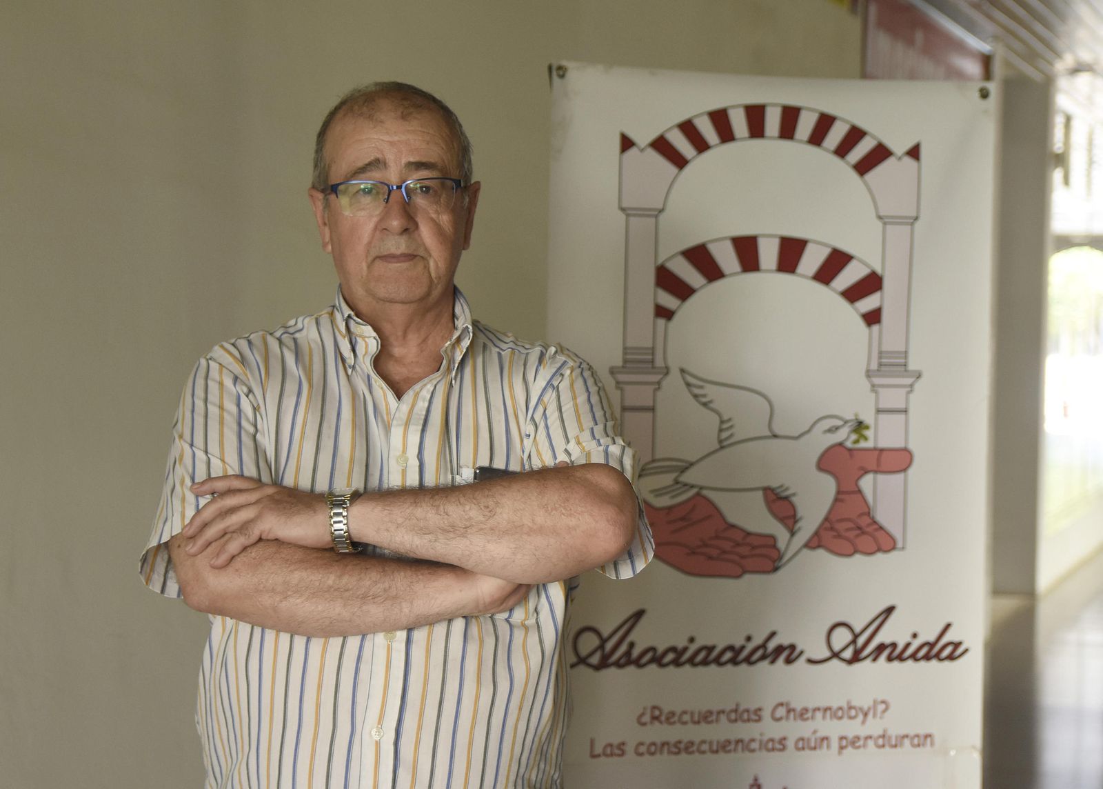 Mariano Pérez de la Concha posa junto al cartel de la asociación preside y que hay en la puerta de la sede de la misma.