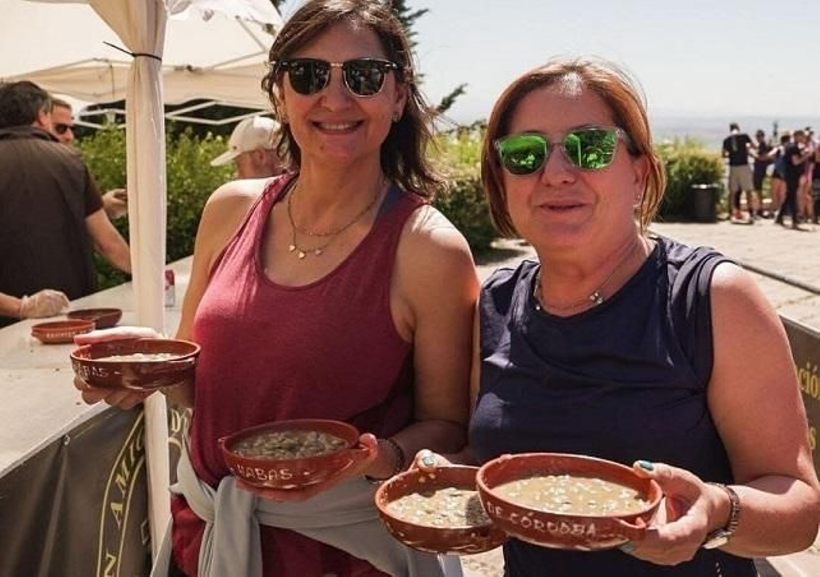 Dos mujeres muestran sus platas de habas.