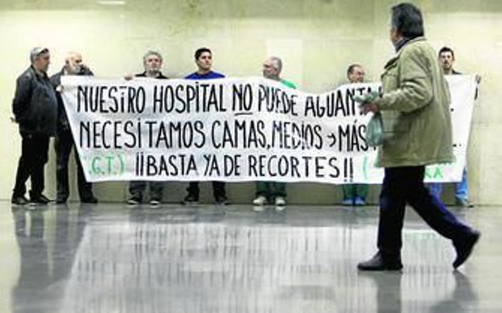 Algunas de las personas que se concentraron ayer en el vestíbulo del Puerta del Mar con una pancarta.