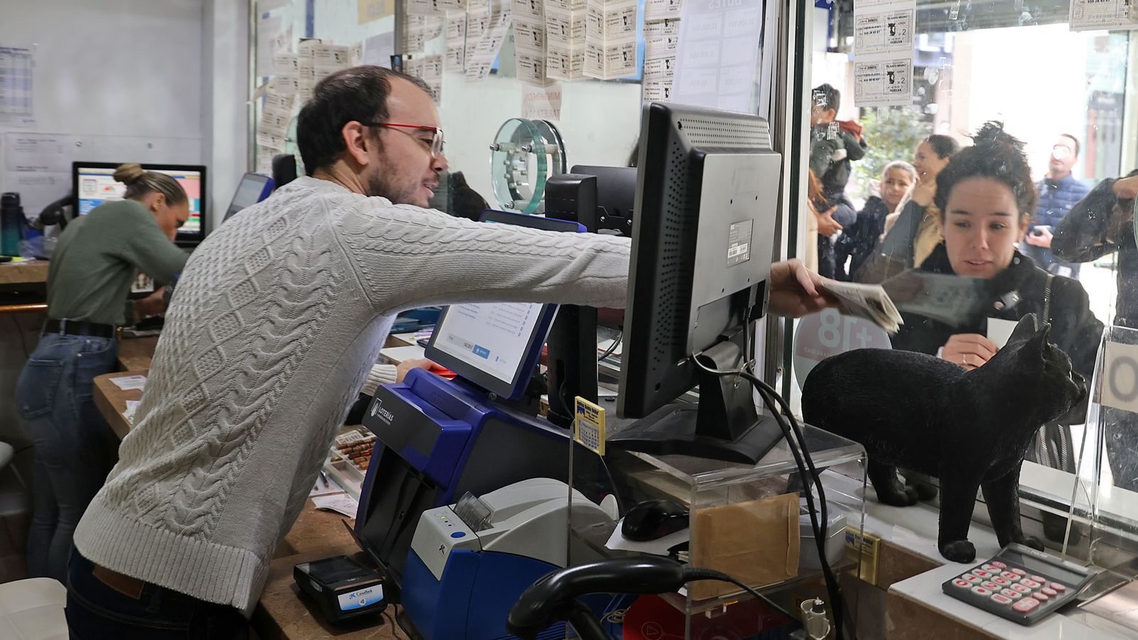 Trabajadores de El Gato Negro atendiendo a los clientes.