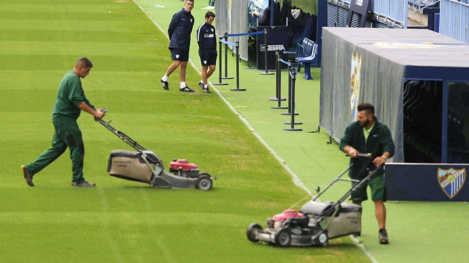 Muñiz observa los trabajados en el césped.