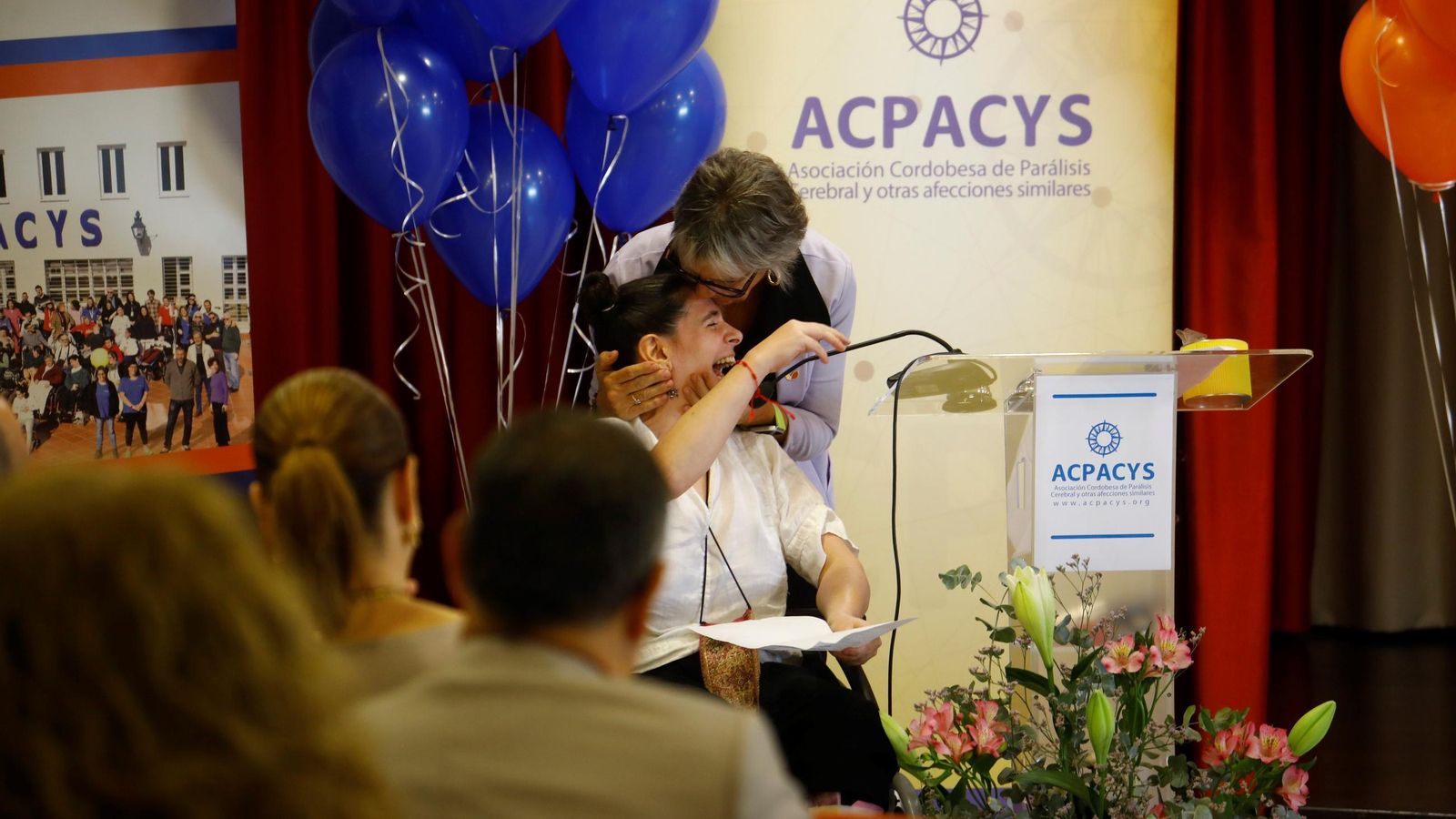 Rafaela Chounavelle abraza a un joven con parálisis cerebral.