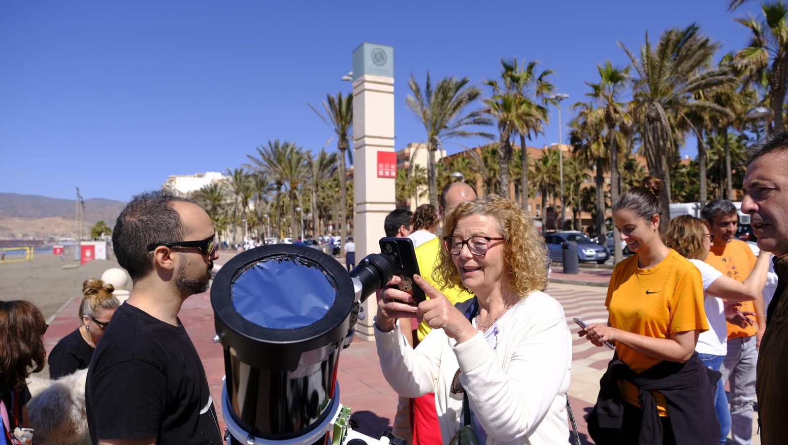 Almería observa el eclipse solar desde el Paseo Marítimo, en imágenes