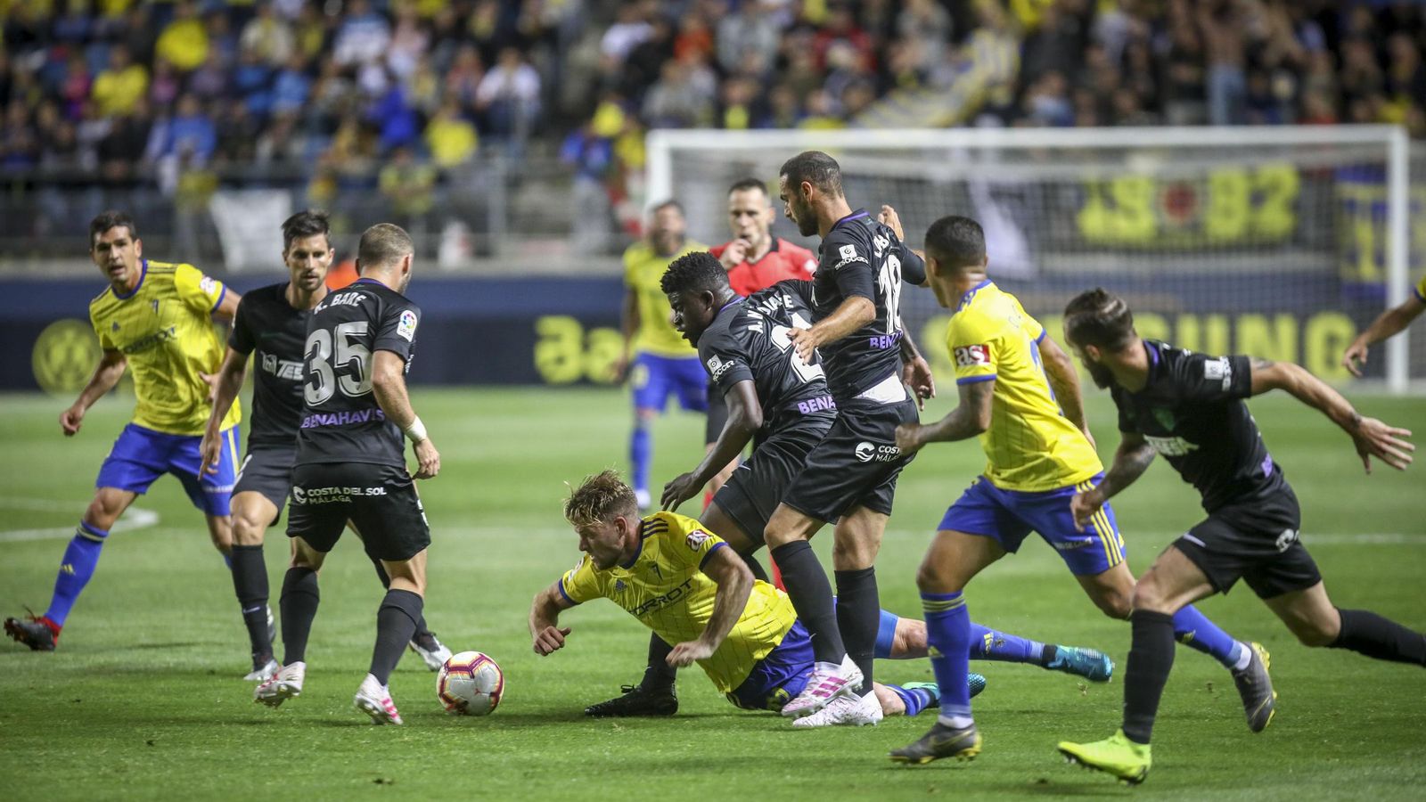 Mario Barco cae rodeado por varios jugadores visitantes.