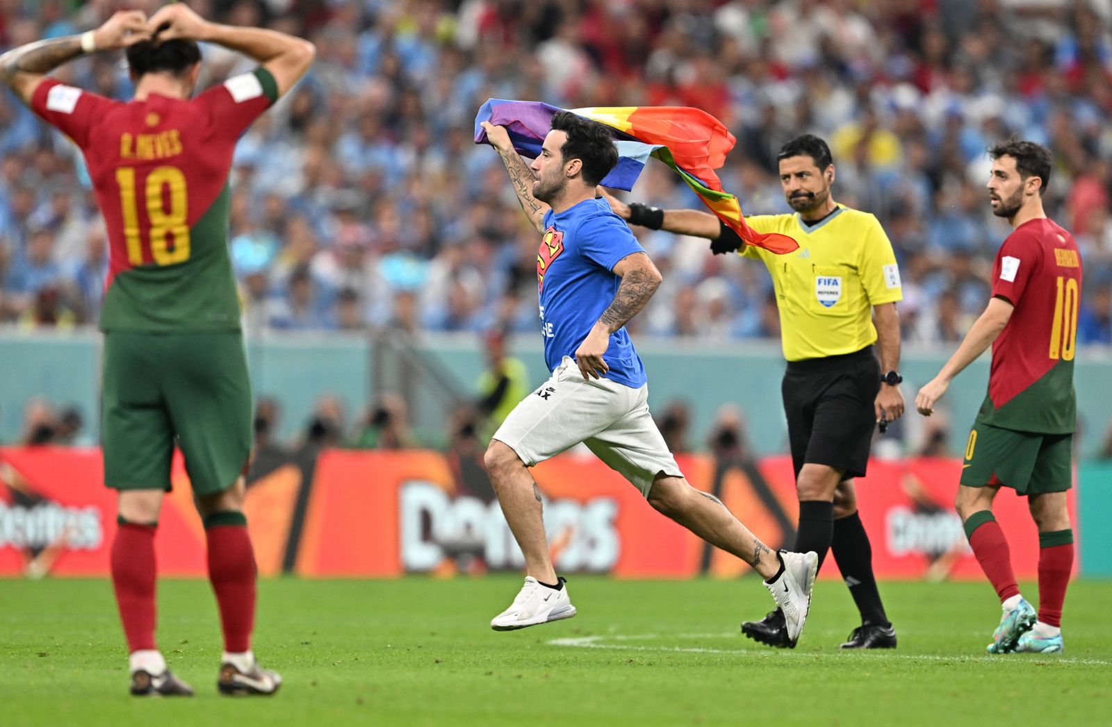 Mario Ferri pasea la bandera arcoíris delante del árbitro y de jugadores portugueses.