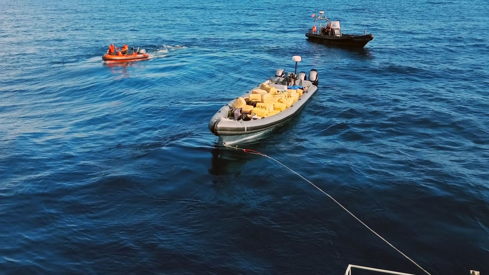 Momento en que el buque de la Armada portuguesa remolca la semirrígida con la droga hasta el puerto de Faro