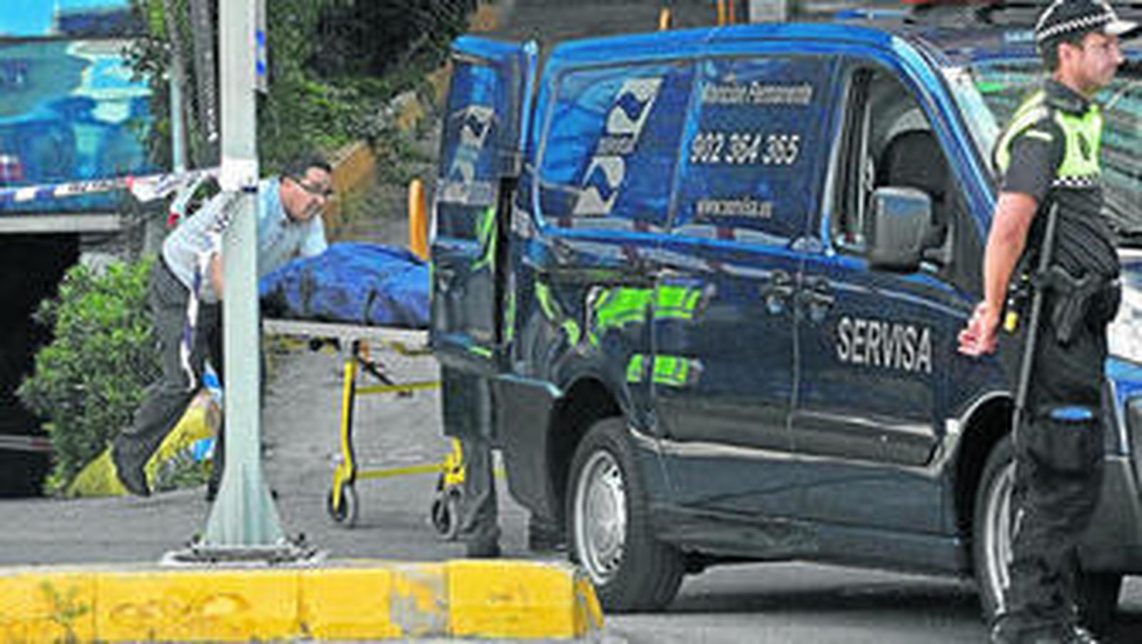 Momento en el que introducen el cadáver en el coche funerario, ayer, en el 'parking' Escalinata.