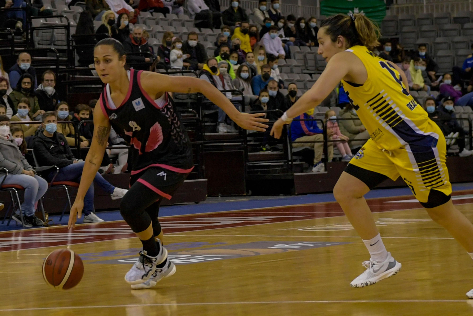 Andrea Boquete bota el balón ante la defensa de una jugadora rival.