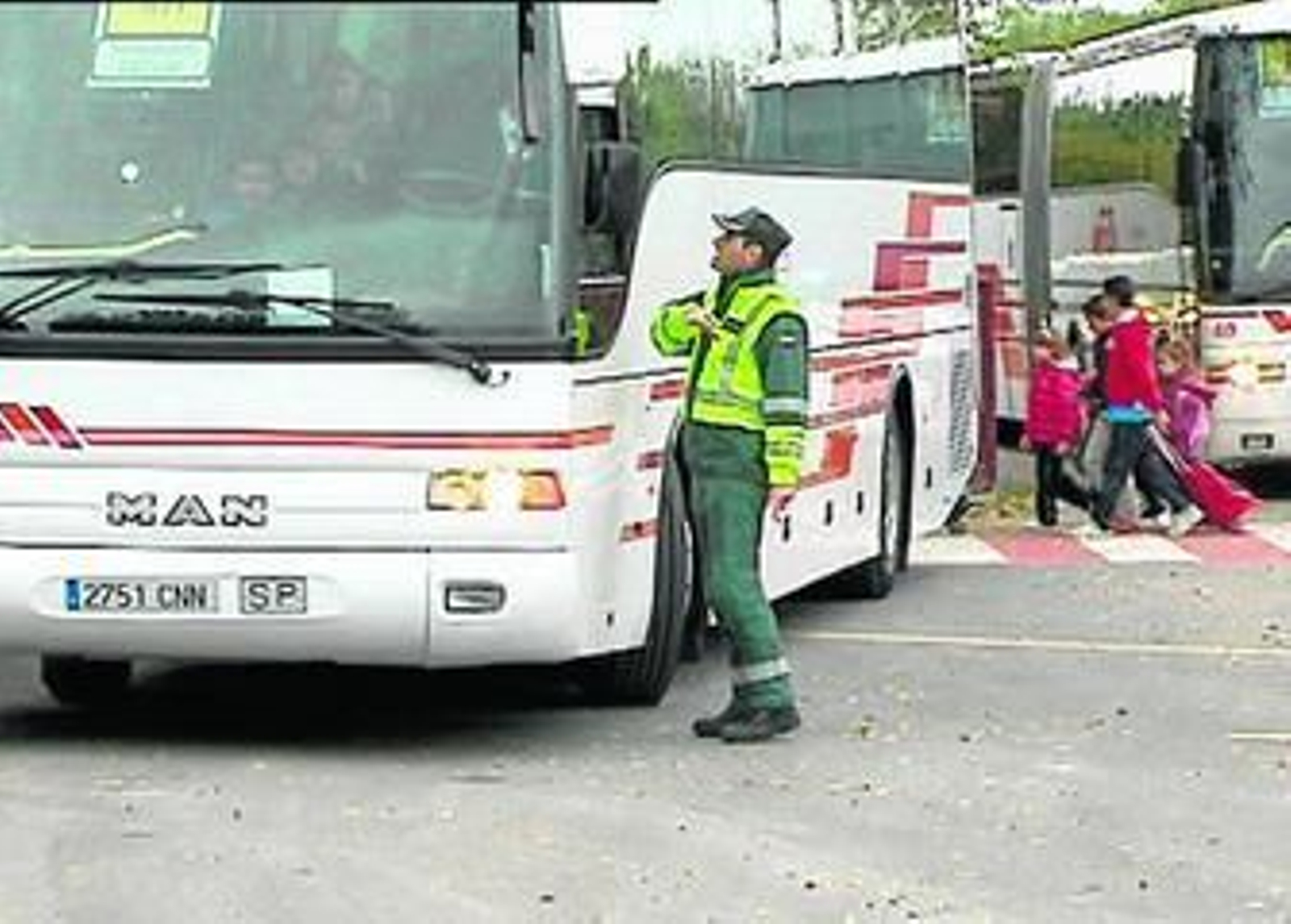Un agente inspecciona un vehículo de transporte escolar.