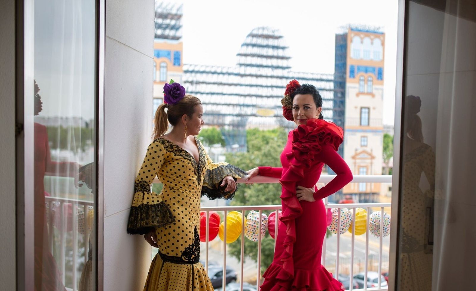 Carmen Trabado y María Eugenia Reina vestidas de flamenca frente a la portada.