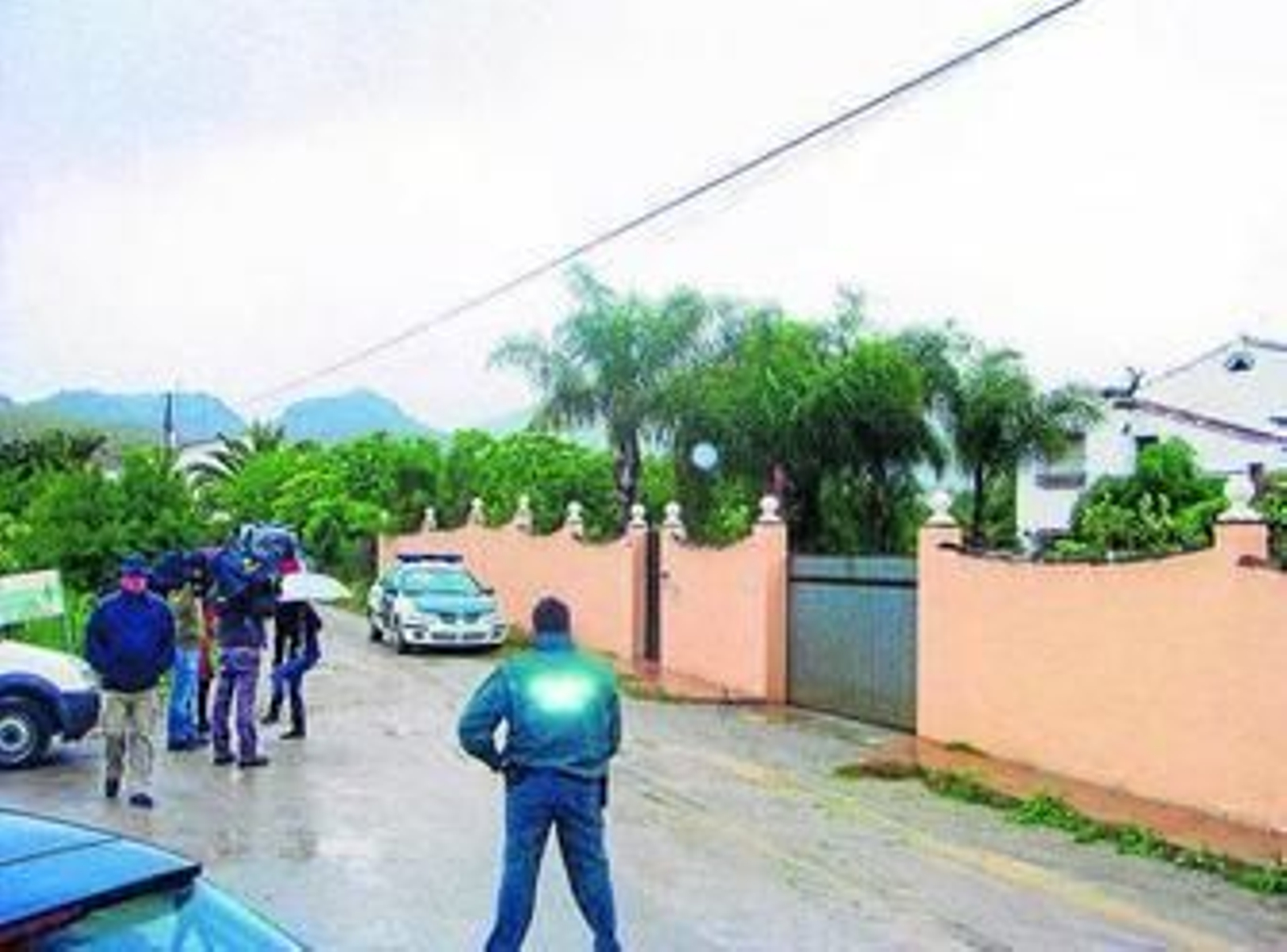 Un agente espera junto a la finca en la que se hallaron los dos cadáveres.