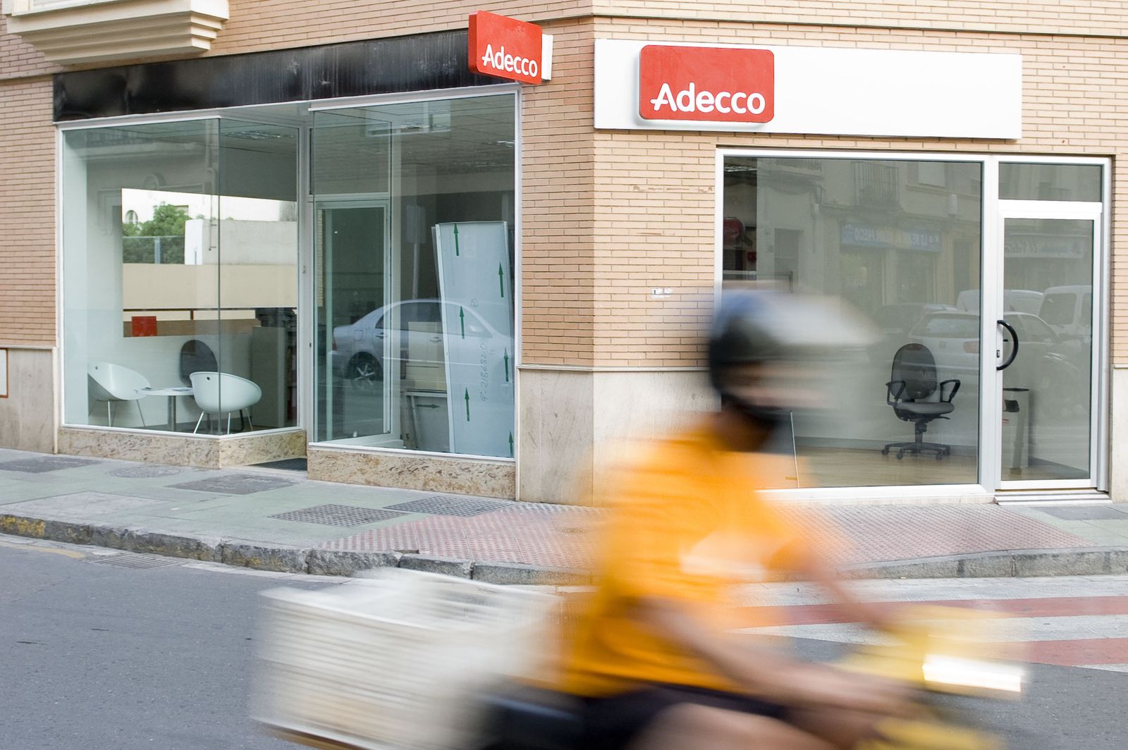 Un motorista pasa delante de una empresa de trabajo temporal.