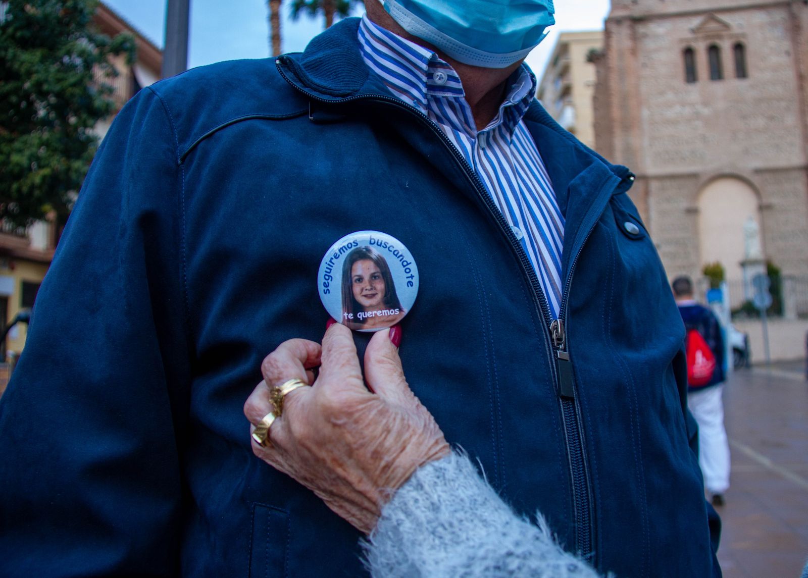 Una mujer coloca una chapa con la imagen de Maria Teresa en el Día Internacional de las Personas Desaparecidas