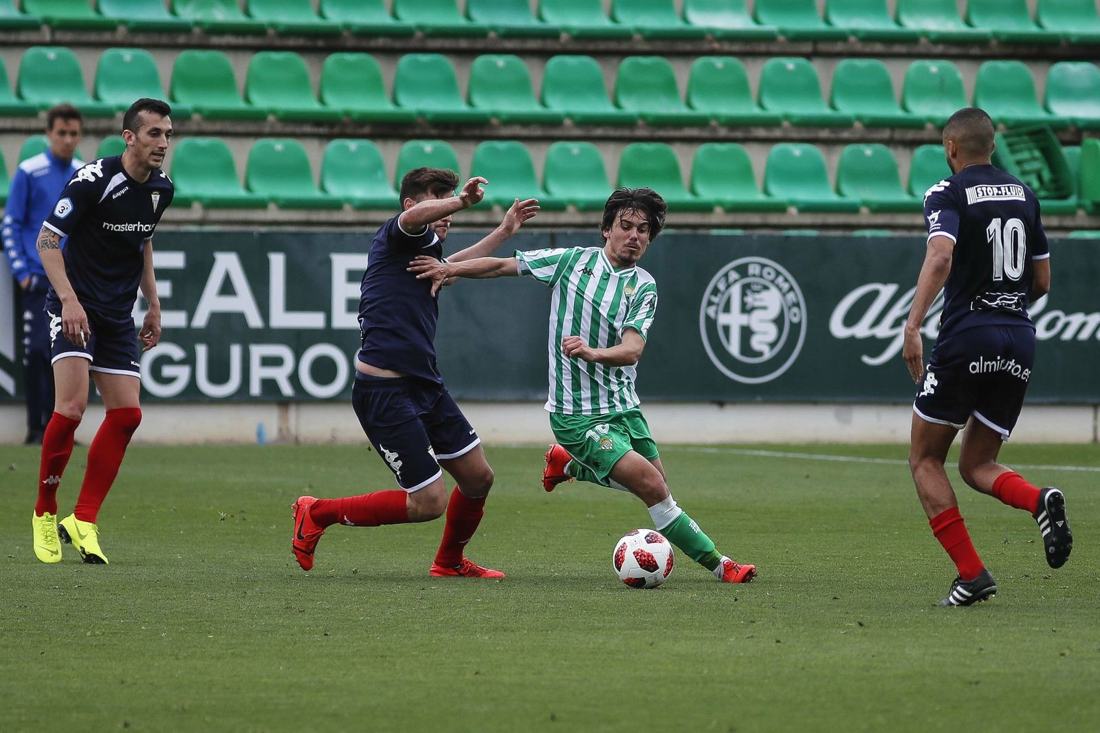 El verdiblanco Rodri disputa un balón dividido ante dos futbolistas del Algeciras.